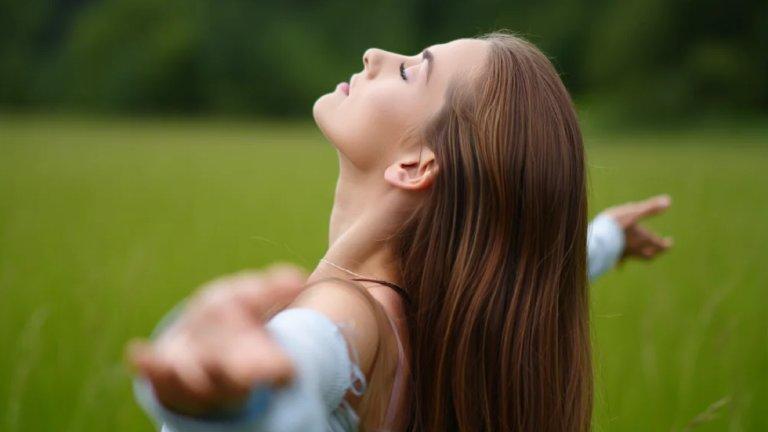 Vrouw ademt vrij in een groen veld: opgelucht na traumatherapie met EMDR en IFS, voor cliënten uit Lier